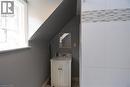 Compact bathroom featuring a white vanity with a basin sink and a framed mirror - 242 James Street S, Hamilton, ON 