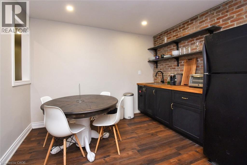 Compact kitchen area featuring dark wood-finish flooring and light-toned walls - 242 James Street S, Hamilton, ON