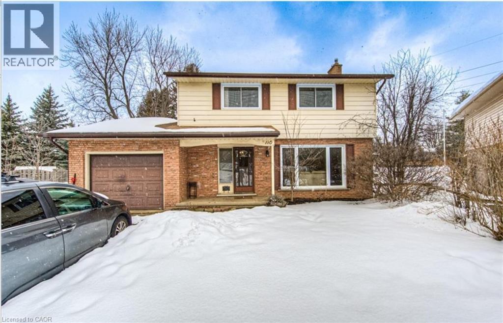 Two-story residence featuring a brick and siding exterior, an attached garage with a brown door, and a prominent front window - 110 Wren Place Unit# Upper, Kitchener, ON - Outdoor