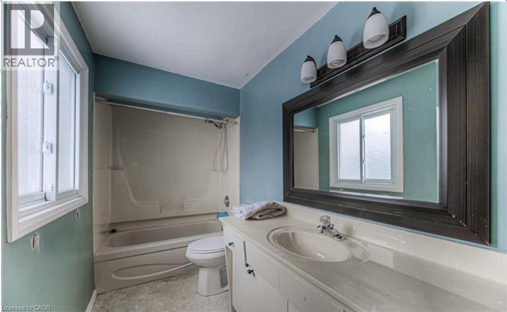 Bathroom featuring a vanity with an integrated sink, a large framed mirror, and a three-light fixture - 110 Wren Place Unit# Upper, Kitchener, ON - Indoor Photo Showing Bathroom