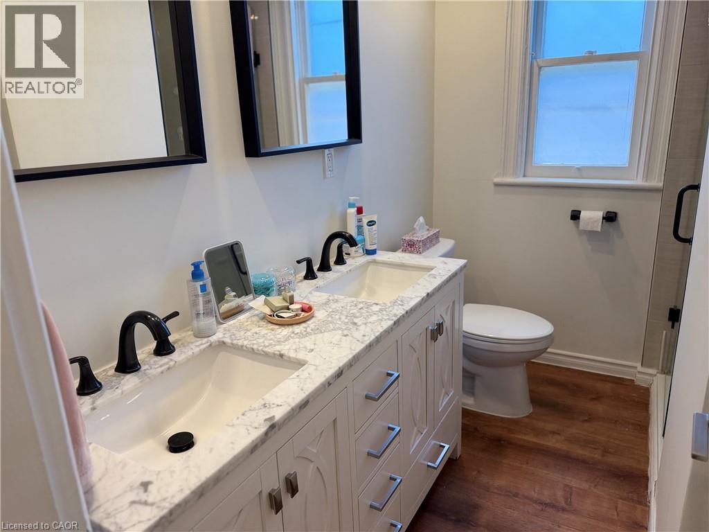 Double vanity with a stone countertop and matte black fixtures - 207 Charlton Avenue W, Hamilton, ON