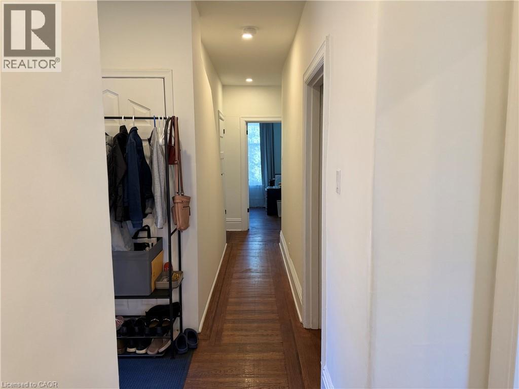 Hallway with wood-finish flooring and recessed lighting - 207 Charlton Avenue W, Hamilton, ON