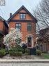 Brick exterior with black trim and a gabled roofline - 207 Charlton Avenue W, Hamilton, ON 