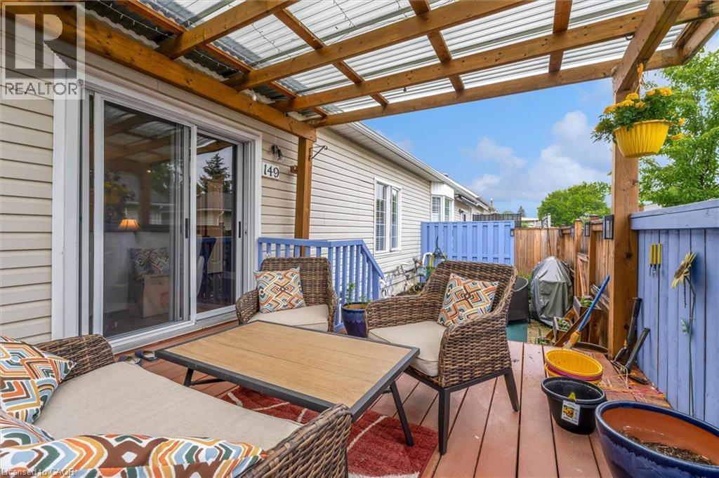 Covered deck featuring wood-finish flooring and a translucent corrugated roof - 149 Silverbirch Boulevard, Hamilton, ON