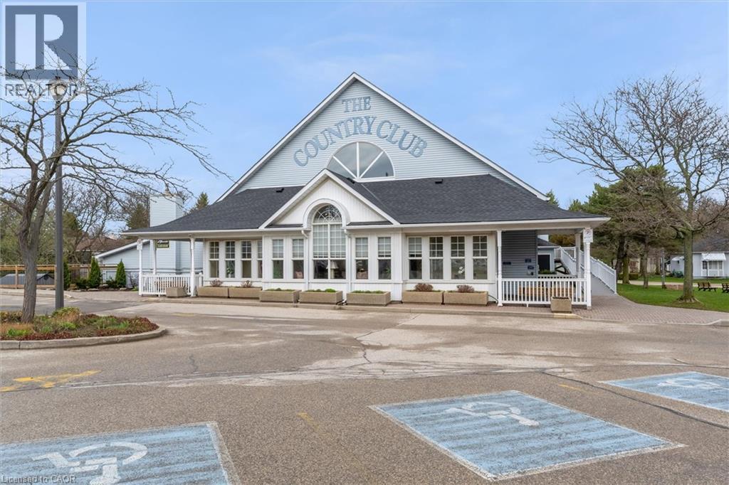 Gable-roofed building featuring white siding and a prominent ""THE COUNTRY CLUB"" inscription - 149 Silverbirch Boulevard, Hamilton, ON