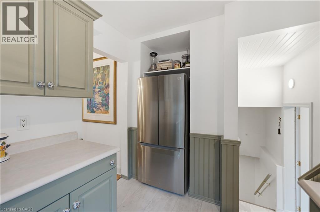 Stainless steel French door refrigerator, light wood-finish flooring, and two-tone wall paneling with a beadboard lower section - 81 Vale Avenue, St. Catharines, ON