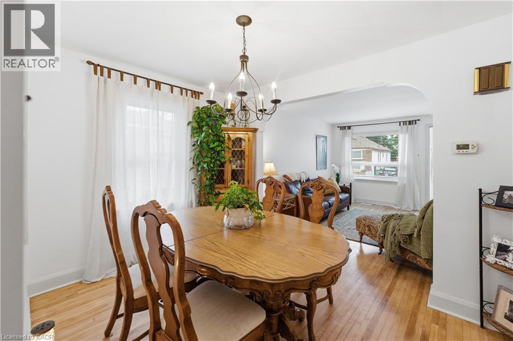 Dining area featuring hardwood flooring and a chandelier - 81 Vale Avenue, St. Catharines, ON