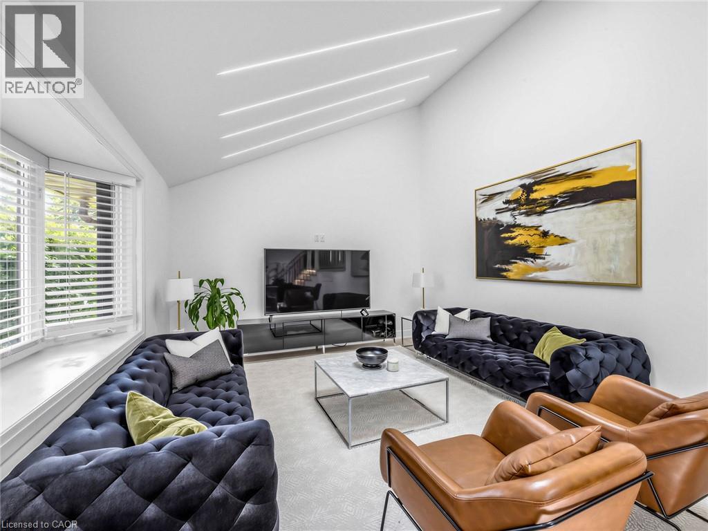 Spacious living area featuring a vaulted ceiling with linear lighting, a large bay window, and light-toned wall-to-wall carpeting - 13 Swanhurst Boulevard, Mississauga, ON - Indoor Photo Showing Living Room