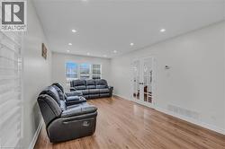 Bright living area featuring wood-finish flooring, recessed lighting, and white walls -