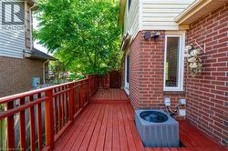 Red-stained wooden deck featuring matching railings and a privacy gate -