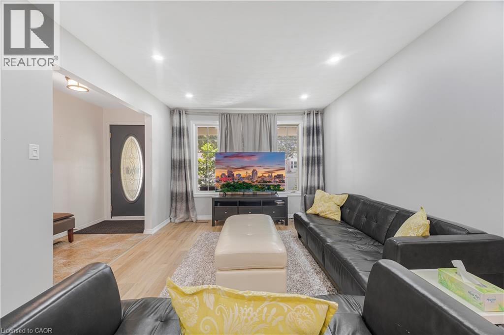 Bright living area featuring recessed lighting, wood-finish flooring, and white painted walls - 23 Millpond Place, Mountain, ON