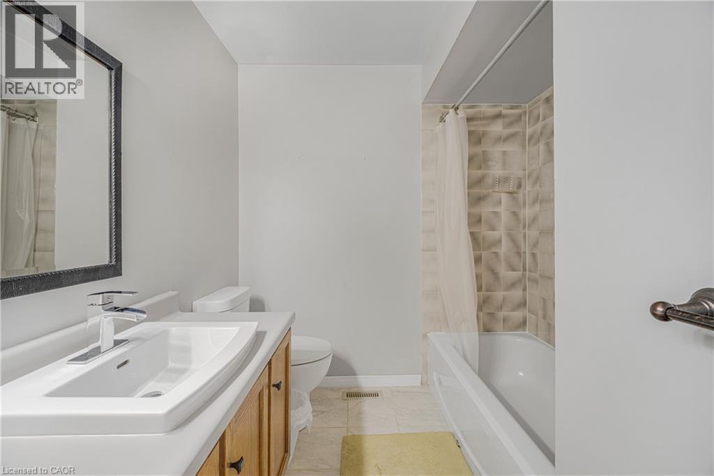 Bathroom vanity featuring a rectangular undermount sink, chrome faucet, and wood-finish cabinetry - 23 Millpond Place, Mountain, ON
