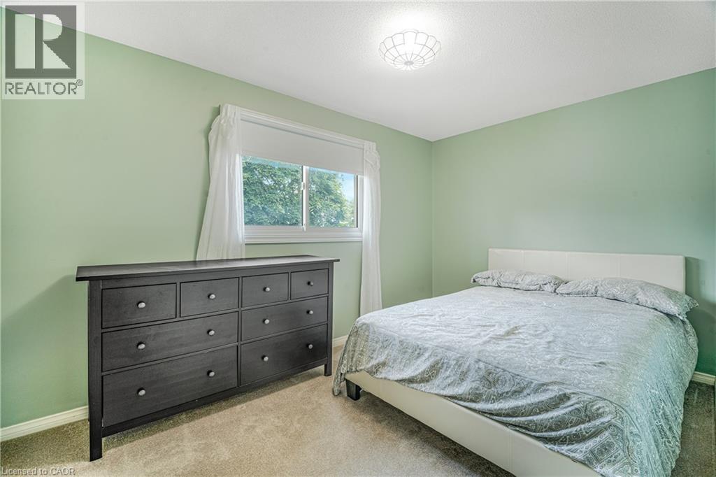 Carpeted room with a double window, light green wall paint, and a ceiling-mounted light fixture - 23 Millpond Place, Mountain, ON