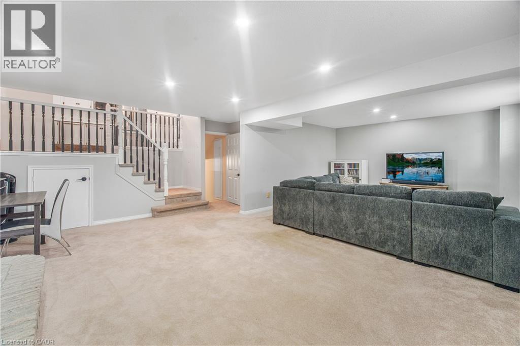 Spacious lower level featuring light-toned carpeting, recessed lighting, painted walls, a balustrade staircase, and a built-in storage area - 23 Millpond Place, Mountain, ON