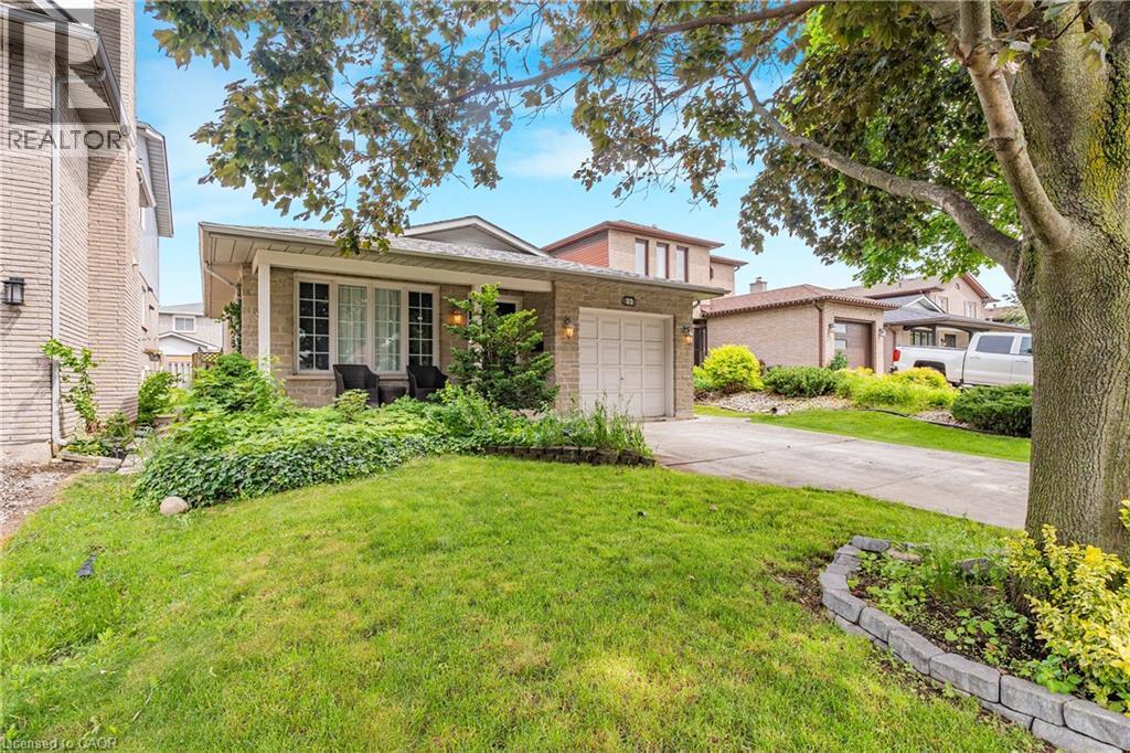 Brick exterior home with an attached garage, paved driveway, and manicured front lawn - 23 Millpond Place, Mountain, ON