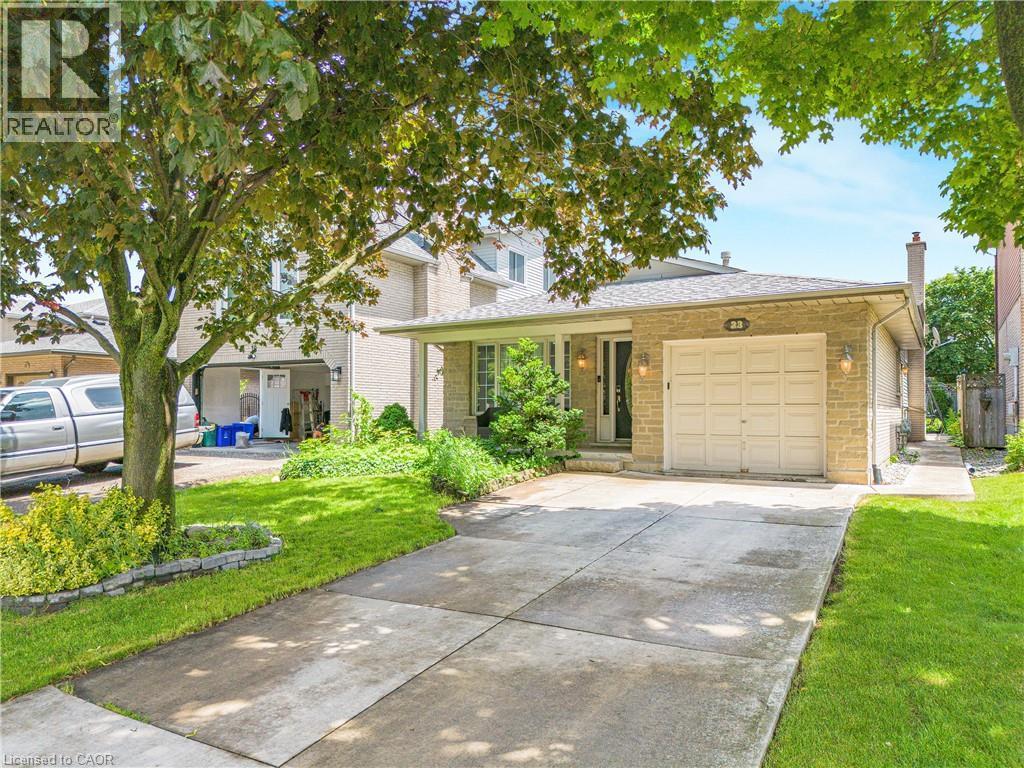 Stone-clad facade with an attached garage and covered front entry - 23 Millpond Place, Mountain, ON