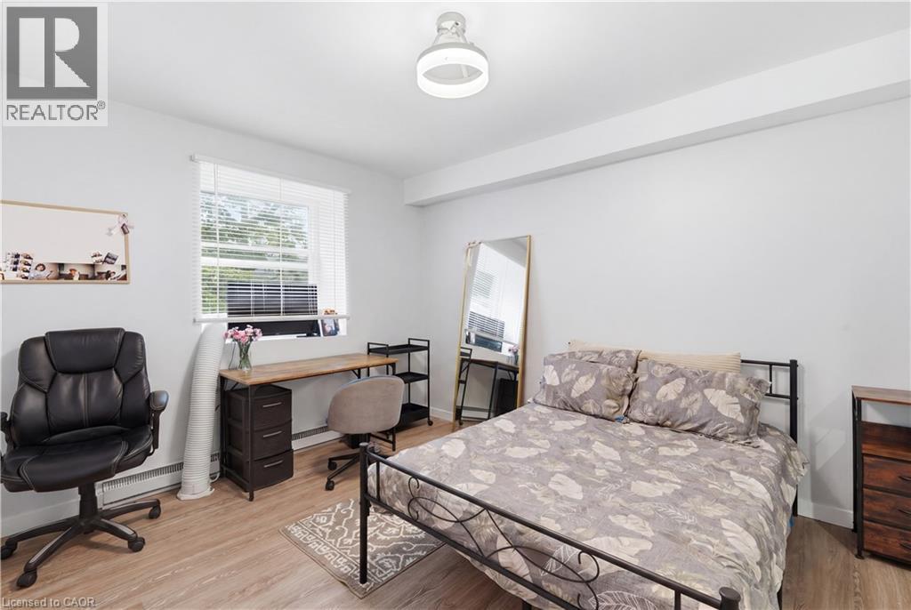 Bedroom featuring wood-finish flooring, a window with blinds, and recessed lighting - 91 Westmount Road Unit# 3, Waterloo, ON
