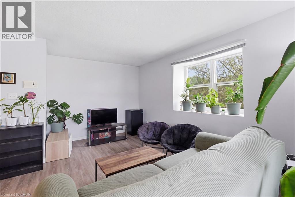 Living area featuring wood-finish flooring and white walls - 91 Westmount Road Unit# 3, Waterloo, ON