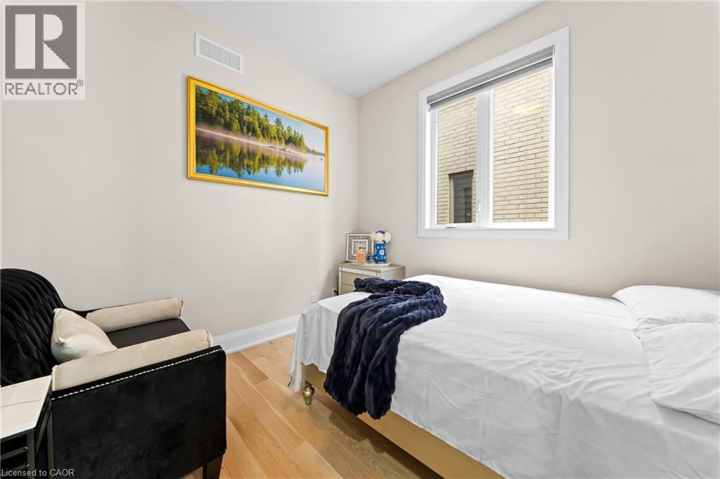 Bright room featuring light-toned walls, wood-finish flooring, and a large window with white trim - 130 Pondcliffe Drive, Kitchener, ON