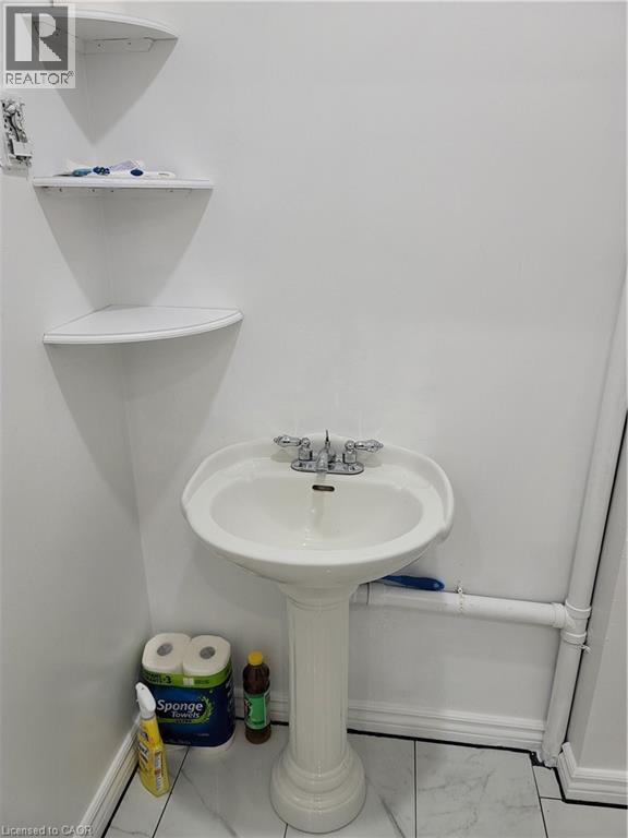Pedestal sink with chrome fixtures and white tile flooring - 648 King Street E, Cambridge, ON
