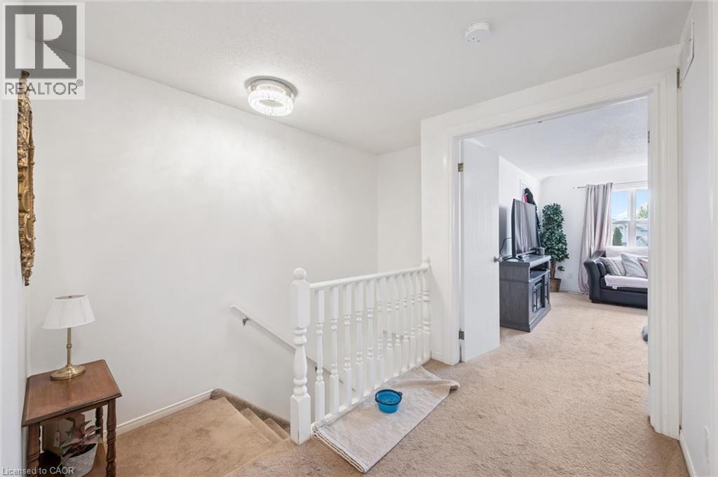 Staircase with white balusters and carpeted treads, leading to a carpeted landing - 765 Angler Way, Waterloo, ON