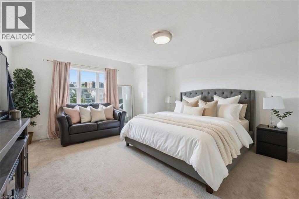 Spacious bedroom featuring light-toned carpeting, white painted walls, and a large window with ample natural light - 765 Angler Way, Waterloo, ON