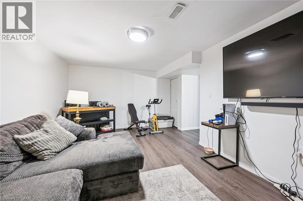 Open-concept interior featuring wood-finish flooring, white walls, and a recessed ceiling light fixture - 765 Angler Way, Waterloo, ON