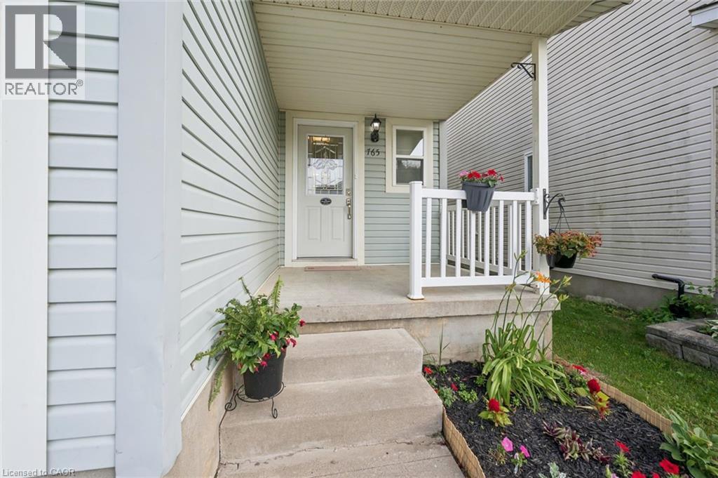 Inviting front entry featuring light blue horizontal siding - 765 Angler Way, Waterloo, ON