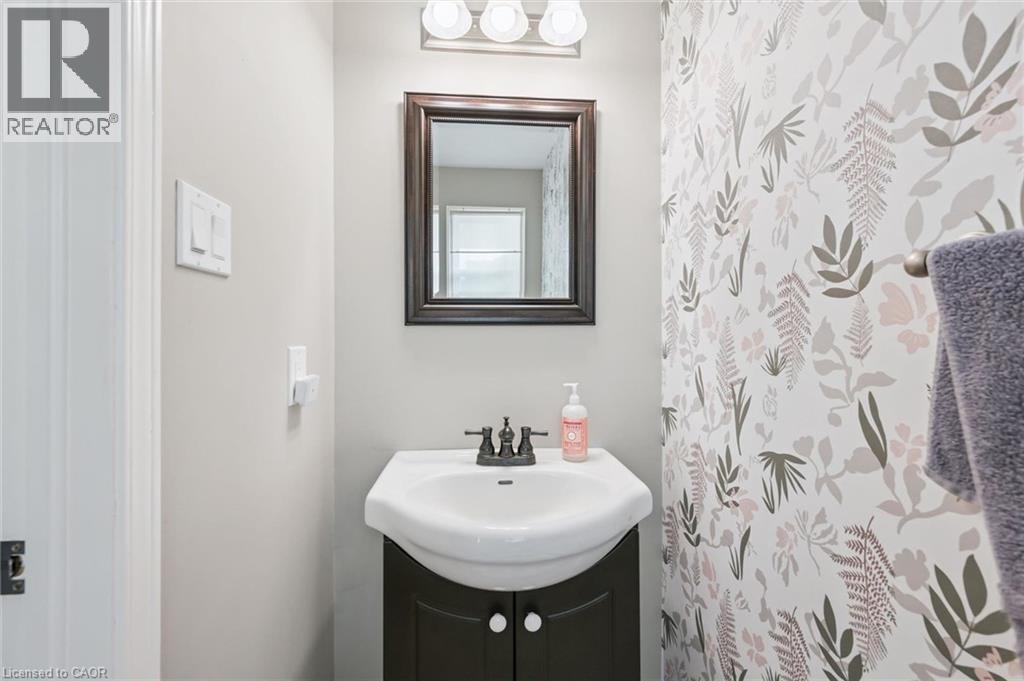 Pedestal vanity with dark wood-finish cabinetry, white ceramic sink, and dark bronze faucet - 765 Angler Way, Waterloo, ON