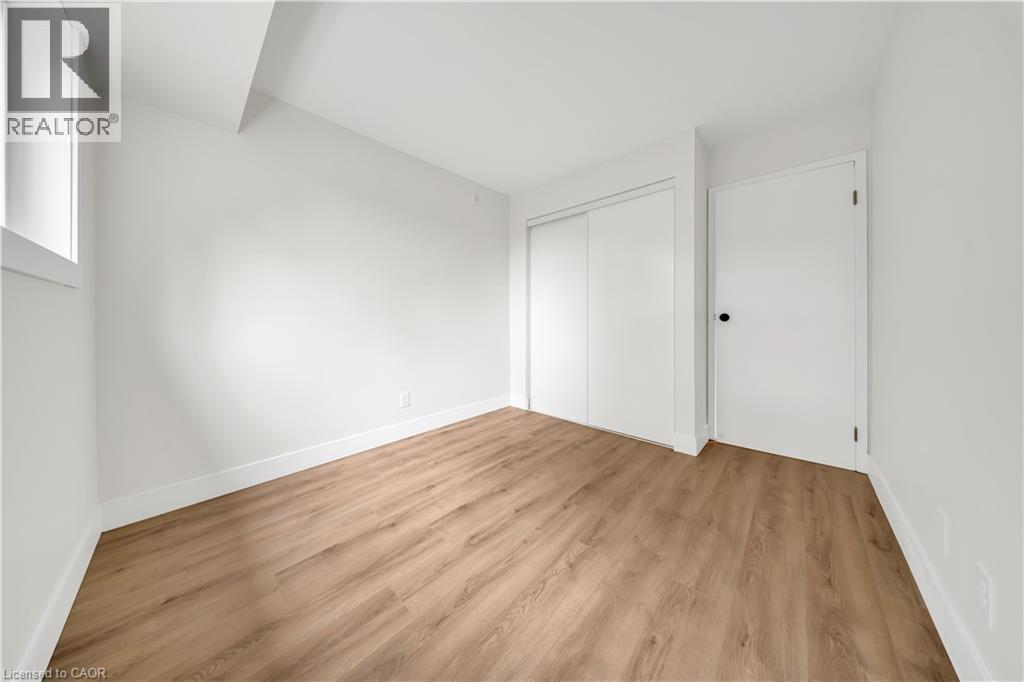Room featuring light wood-finish flooring, white walls, and a white baseboard trim - 3085 Kingsway Drive Unit# 21, Kitchener, ON