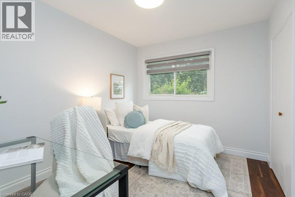 Light-filled room featuring a single window with blinds, wood-finish flooring, a neutral wall color, and white trim - 139 Mackay Crescent, Waterloo, ON