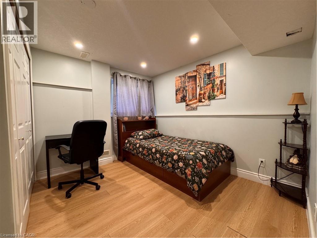 Room featuring wood-finish flooring, recessed ceiling lighting, and a window with curtain rods - 110 Marl Meadow Drive Unit# B, Kitchener, ON