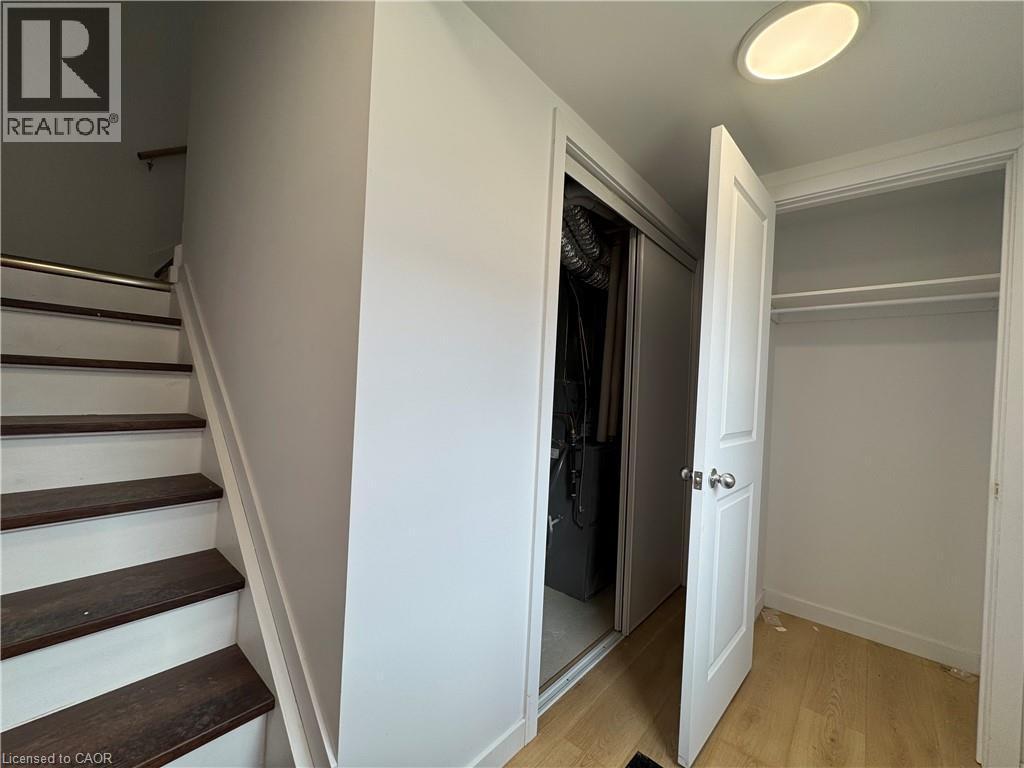 Hardwood stair treads with a white painted riser, neutral wall paint, light wood-finish flooring, and a white recessed ceiling light fixture - 113 Highriver Trail Unit# Main, Welland, ON - Indoor Photo Showing Other Room