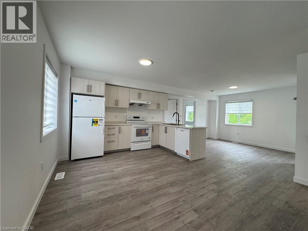 Open-concept living area featuring wood-finish flooring, recessed lighting, and multiple windows with horizontal blinds - 119 Highriver Trail Unit# Main, Welland, ON - Indoor Photo Showing Kitchen