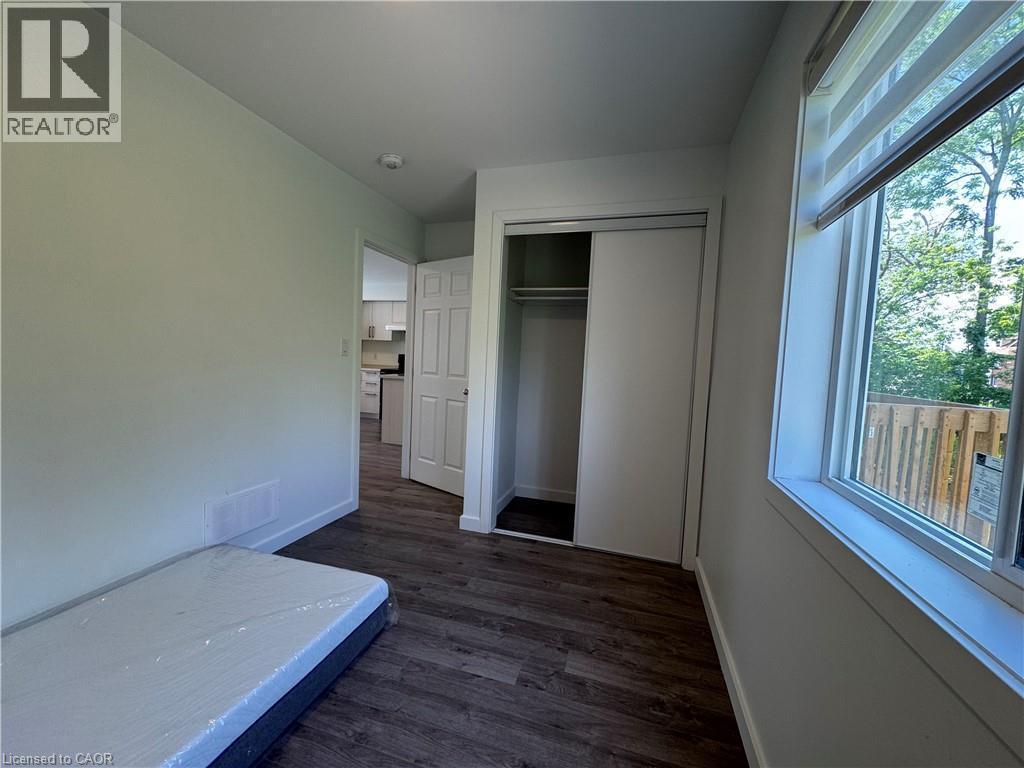 Bright interior room featuring wood-finish flooring, white walls, and a recessed ceiling light - 133 Highriver Trail Unit# Main, Welland, ON