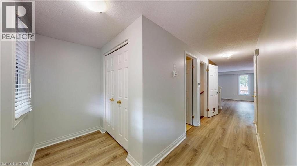 Hallway featuring wood-finish flooring, white trim, and light gray wall paint - 980 Creekside Drive, Waterloo, ON - Indoor Photo Showing Other Room