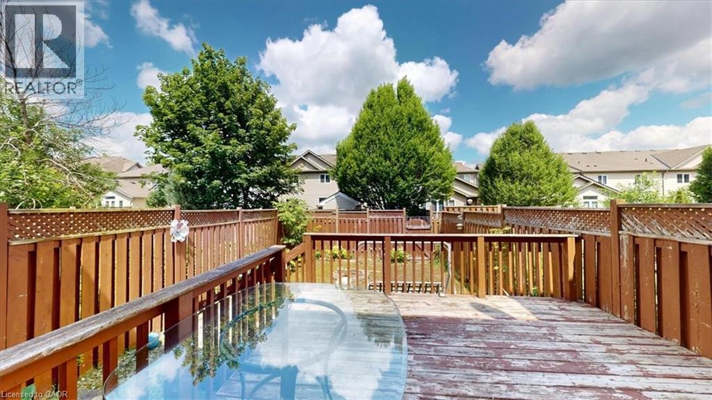 Wood deck with slatted railing and privacy lattice, featuring a backyard space with mature trees - 980 Creekside Drive, Waterloo, ON - Outdoor With Deck Patio Veranda