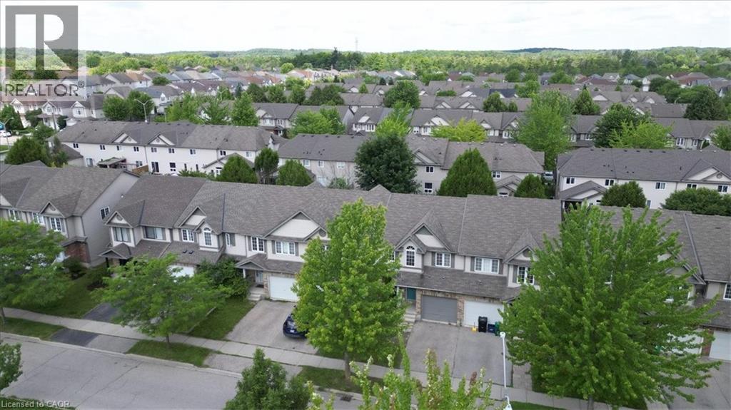 Residential neighborhood with numerous detached and attached properties featuring shingle roofs and light-colored exteriors, bordered by mature trees - 980 Creekside Drive, Waterloo, ON - Outdoor