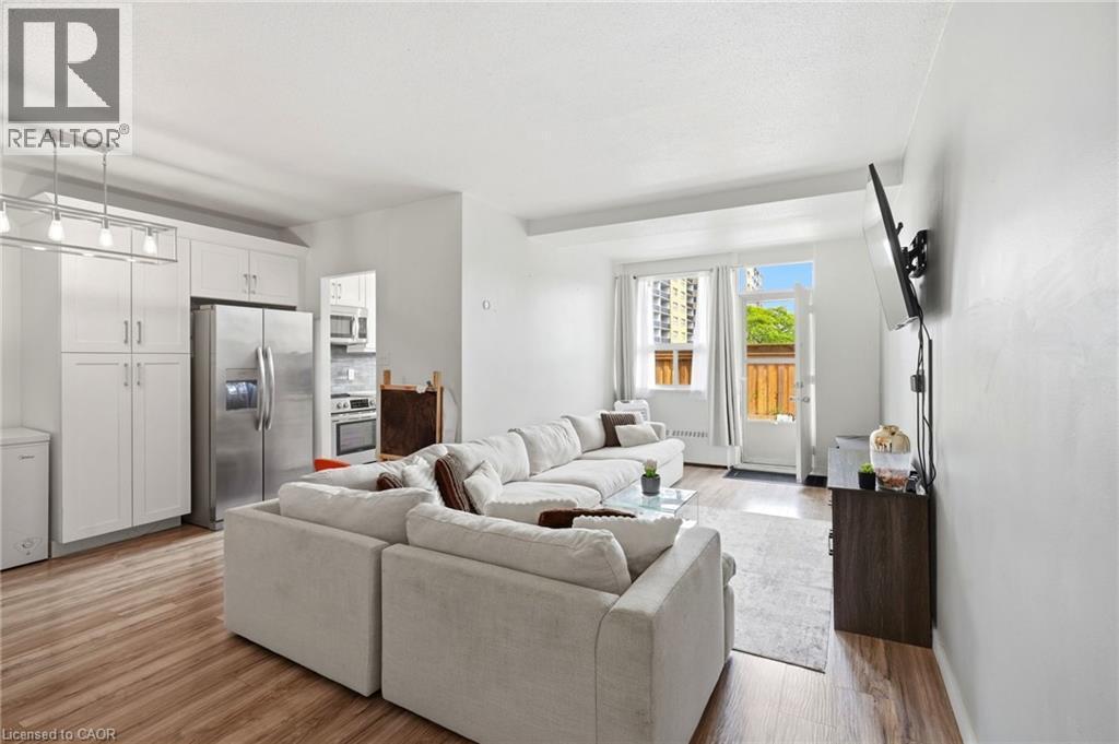 Open-concept living area featuring wood-finish flooring and white walls - 15 Nicklaus Drive Unit# 17, Hamilton, ON