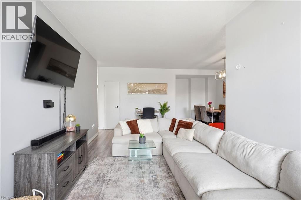 Open-concept living space featuring wood-finish flooring, light grey walls, and recessed lighting - 15 Nicklaus Drive Unit# 17, Hamilton, ON