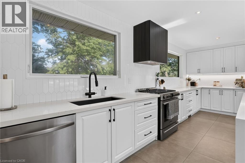 Modern kitchen featuring white shaker cabinetry, light-toned countertops, and a full tile backsplash - 9 Leslie Drive, Hamilton, ON - Indoor Photo Showing Kitchen With Upgraded Kitchen