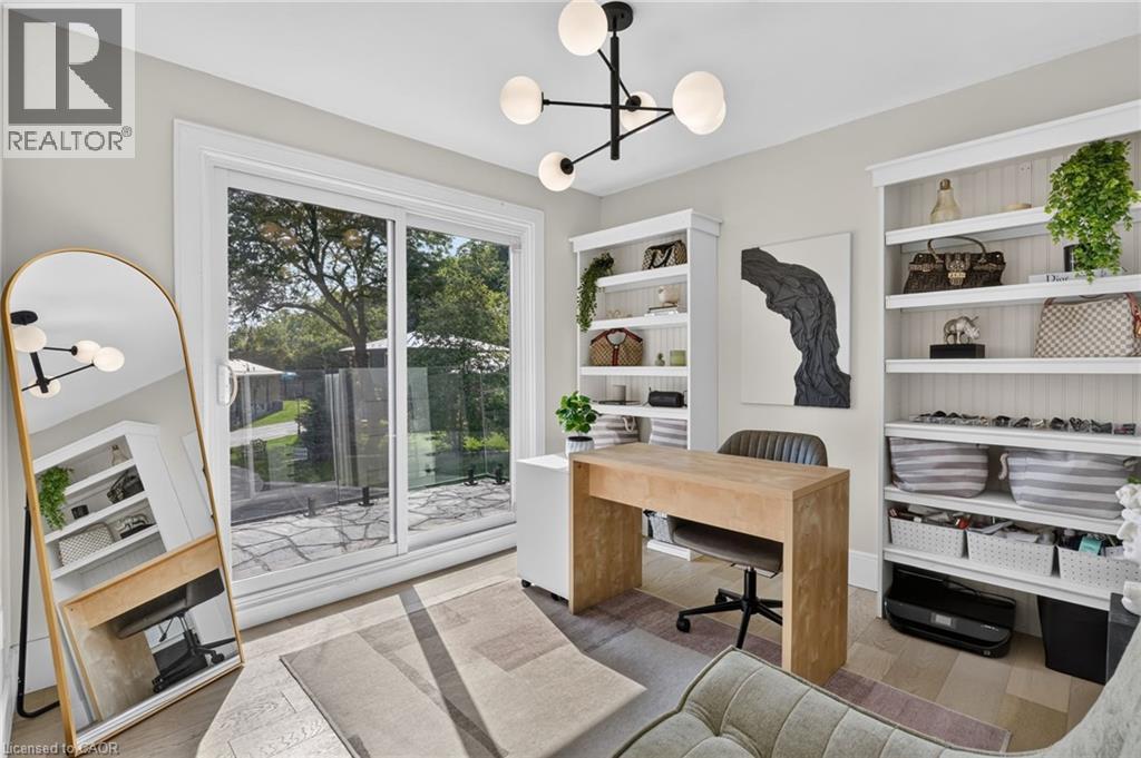 Room featuring wood-finish flooring, a modern chandelier with spherical lights, and light gray wall paint - 9 Leslie Drive, Hamilton, ON - Indoor