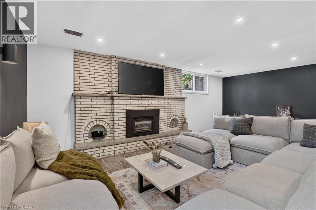 Living area featuring a brick-clad fireplace with a hearth and a built-in firebox - 9 Leslie Drive, Hamilton, ON - Indoor Photo Showing Living Room With Fireplace