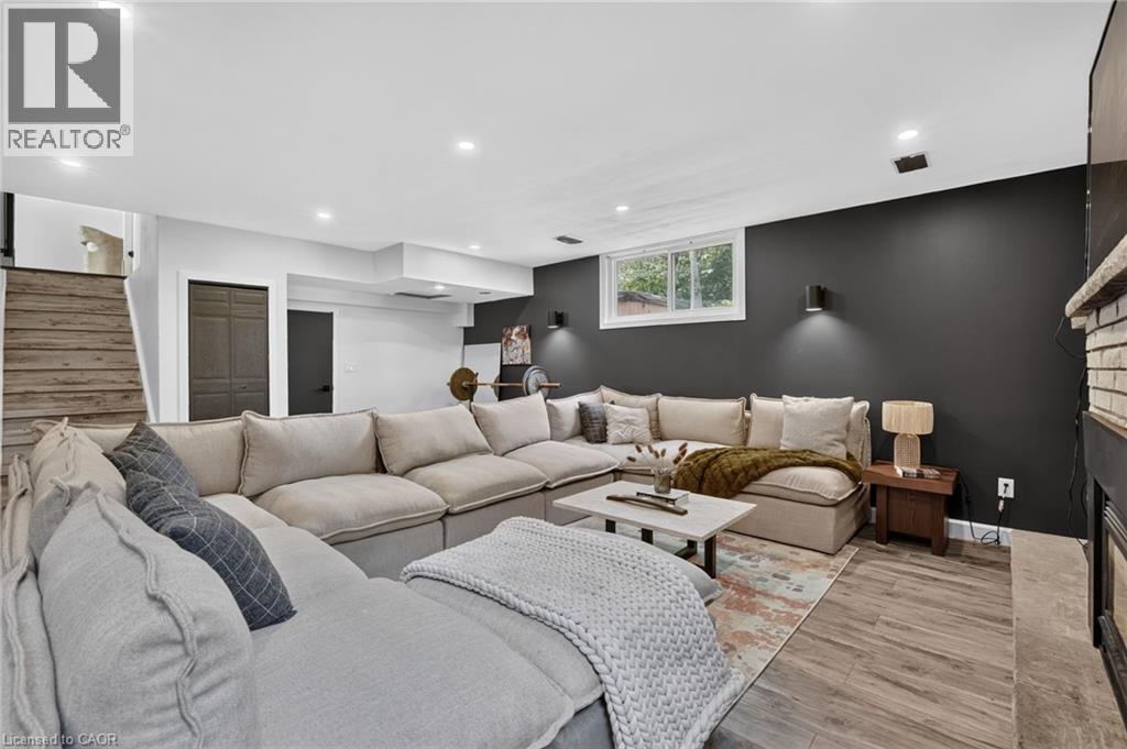 Spacious recreation room featuring wood-finish flooring, recessed lighting, and a window for natural illumination - 9 Leslie Drive, Hamilton, ON - Indoor Photo Showing Living Room