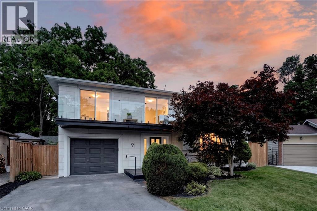 Modern two-story residence featuring a ground-level garage, upper-level balcony with glass railing, and a paved driveway - 9 Leslie Drive, Hamilton, ON - Outdoor