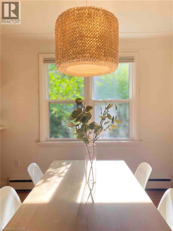Woven pendant light fixture over a light wood-finish table - 919 Montgomery Drive, Ancaster, ON