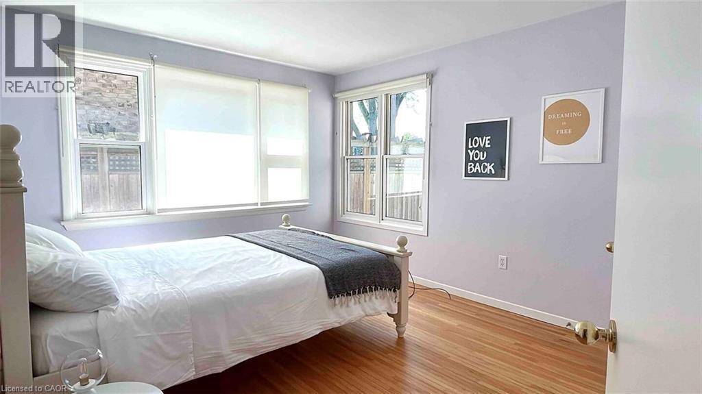 Hardwood flooring with a natural finish, white baseboards, and light-toned walls - 919 Montgomery Drive, Ancaster, ON