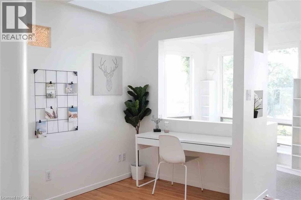 Bright interior space featuring white walls and wood-finish flooring - 919 Montgomery Drive, Ancaster, ON