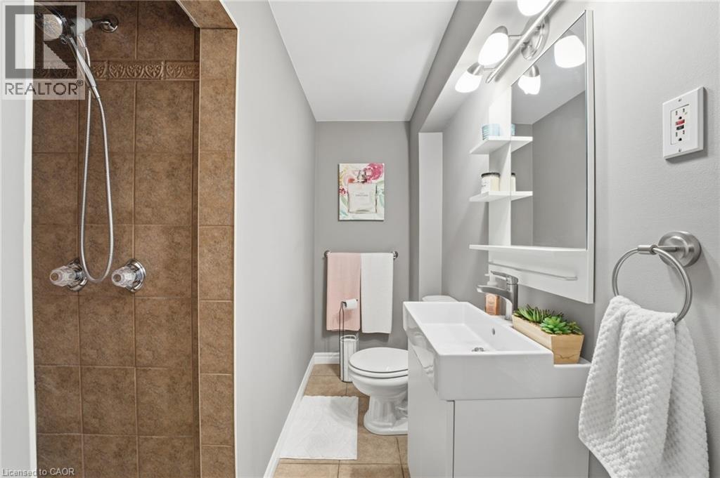 Bathroom featuring a stall shower, vanity, and light tile patterned flooring - 473 Mohawk Road W, Hamilton, ON