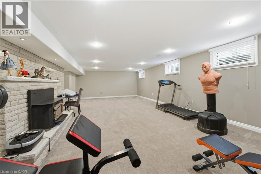 Workout room featuring a fireplace, light carpet, and recessed lighting - 473 Mohawk Road W, Hamilton, ON